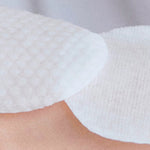Close-up of textured Korean toner pads on skin, skincare exfoliating cotton rounds