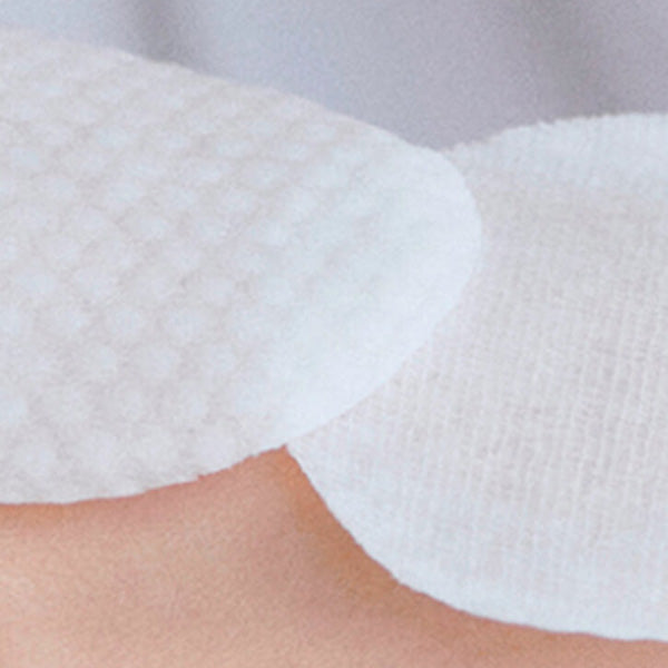 Close-up of textured Korean toner pads on skin, skincare exfoliating cotton rounds